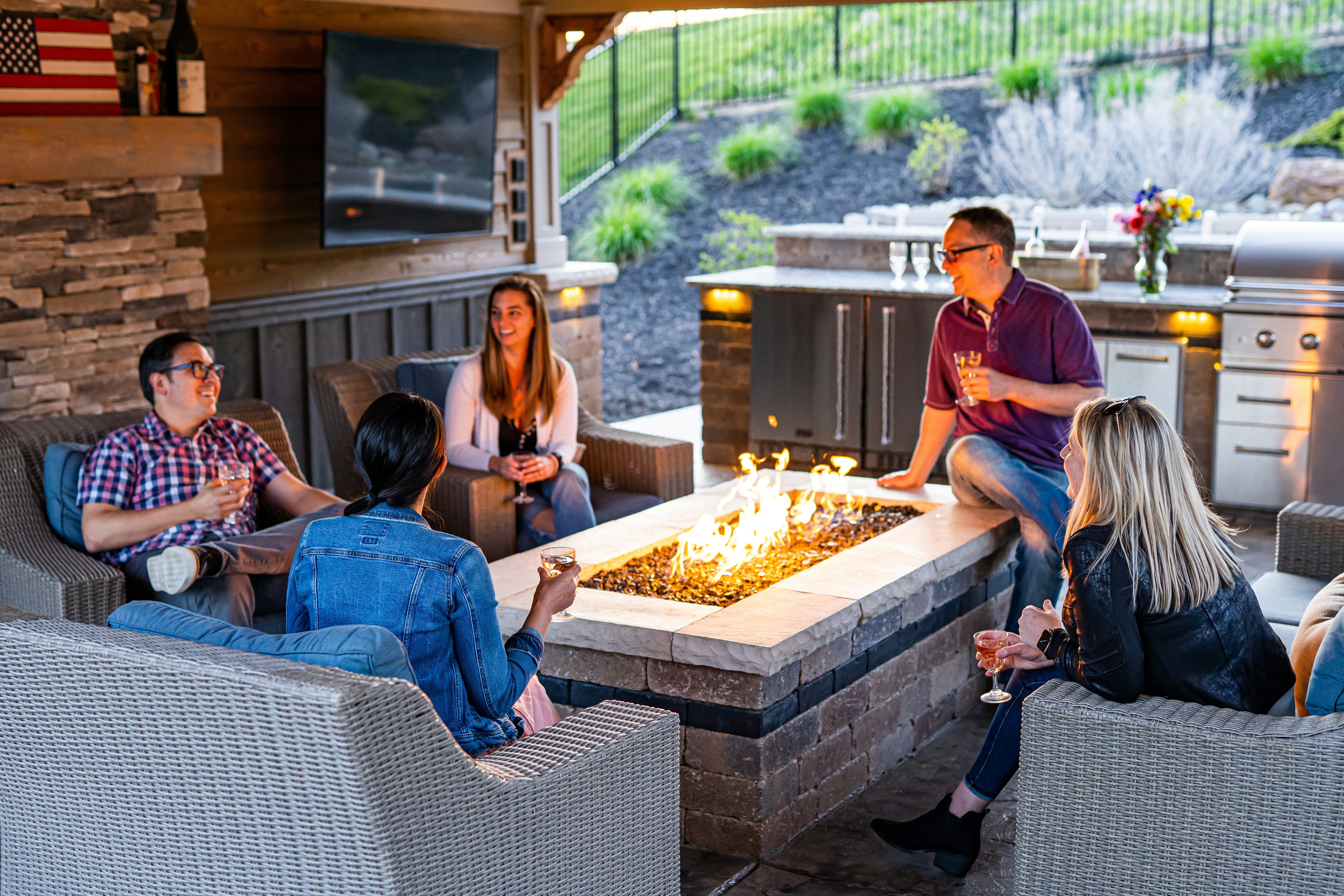❓ FAQ: Your Burning Backyard Tech Questions Answered by TV Brands a group of people sitting around a table with a fire in it