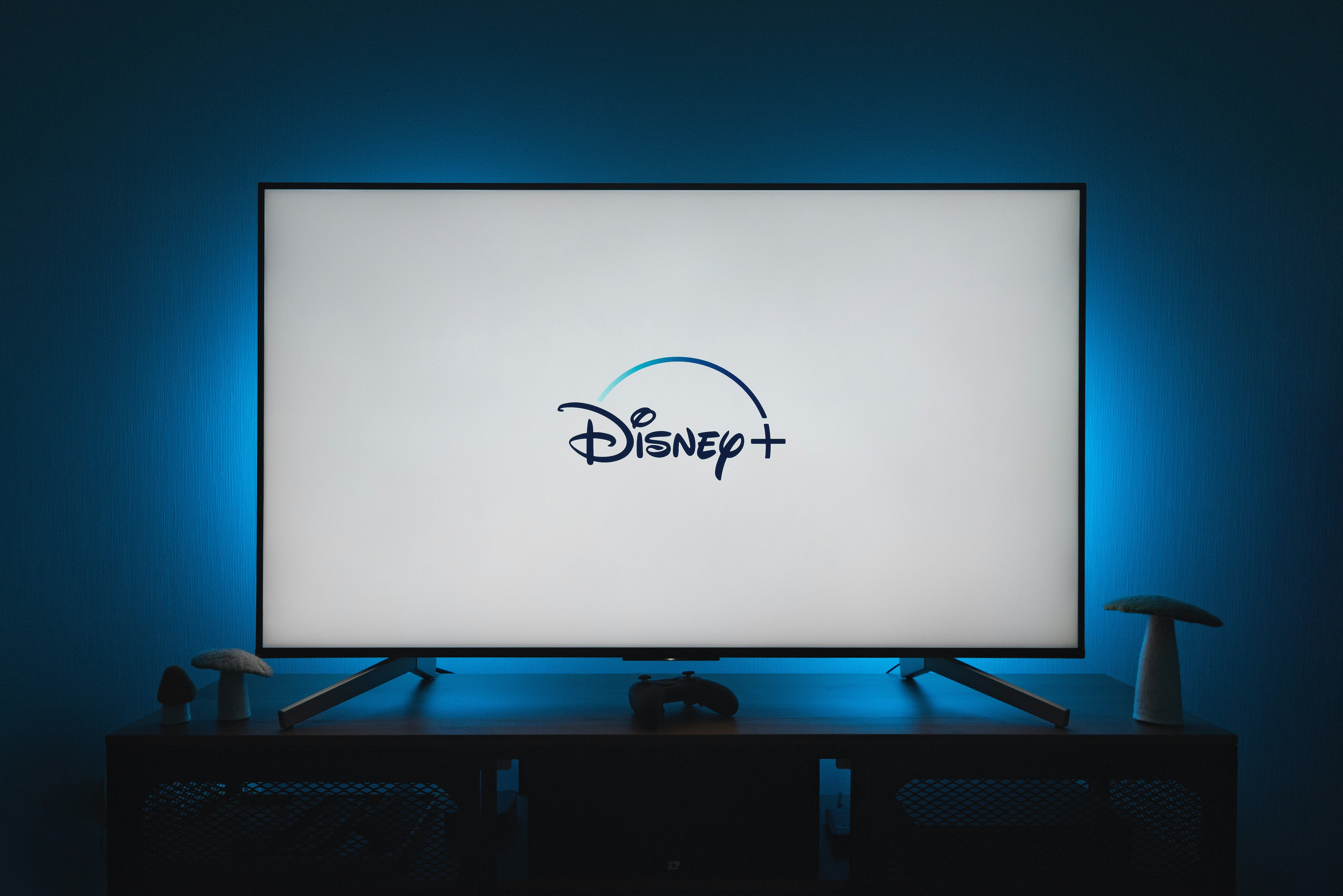 Watching Disney Plus on a TV by TV Brands a flat screen tv sitting on top of a wooden table