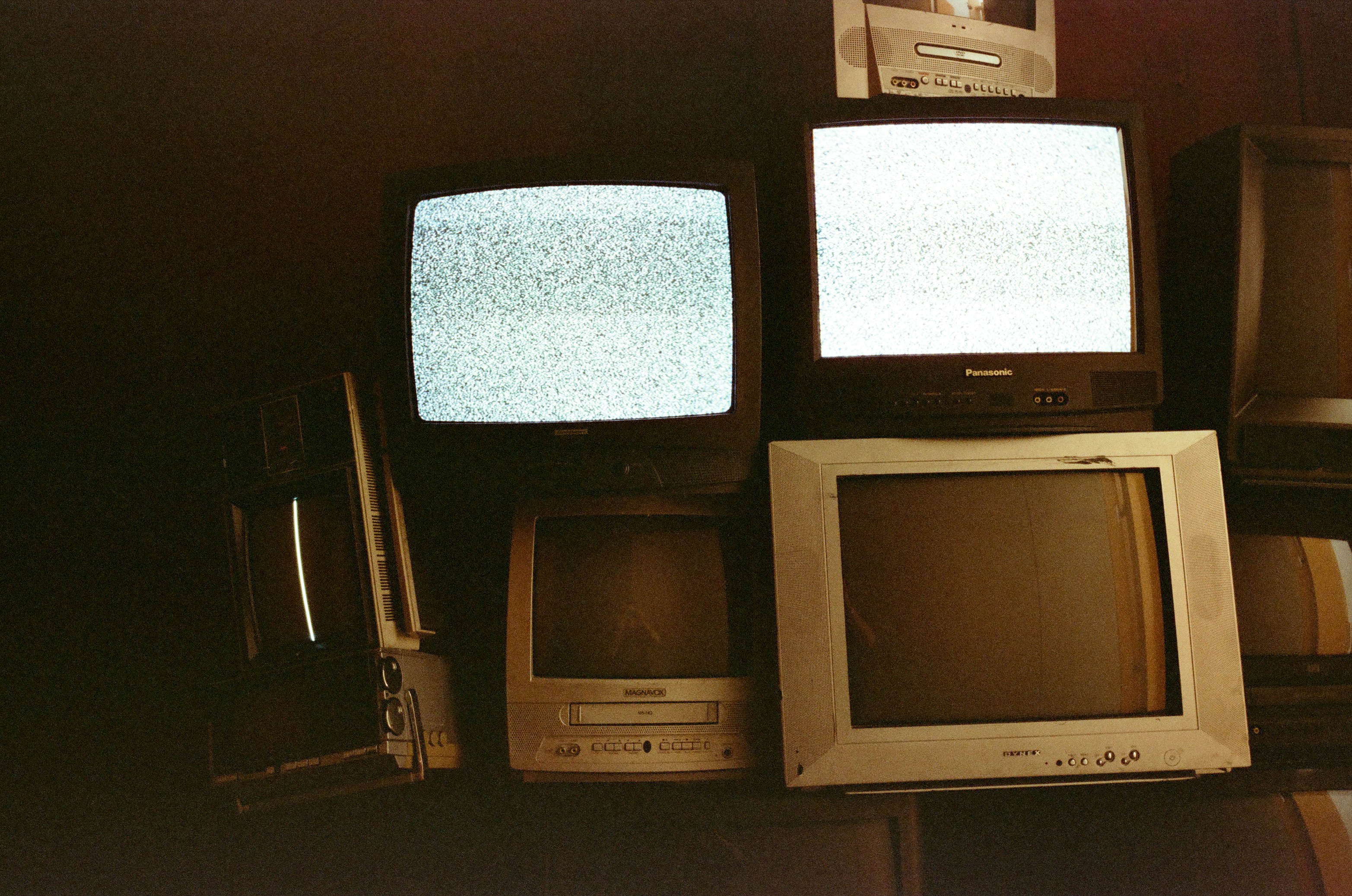 Stack of old televisions displaying static