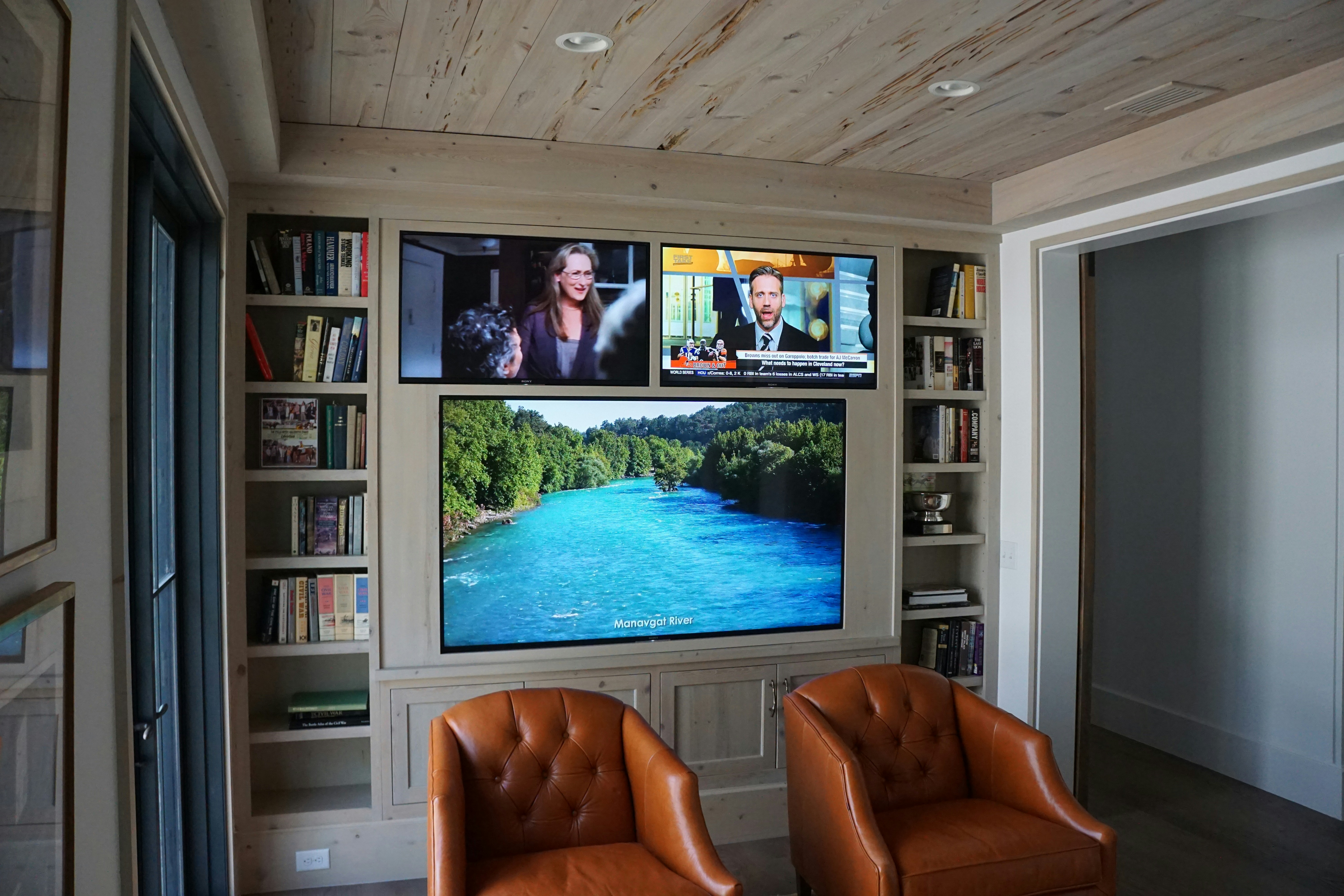 a room with a tv and bookshelves