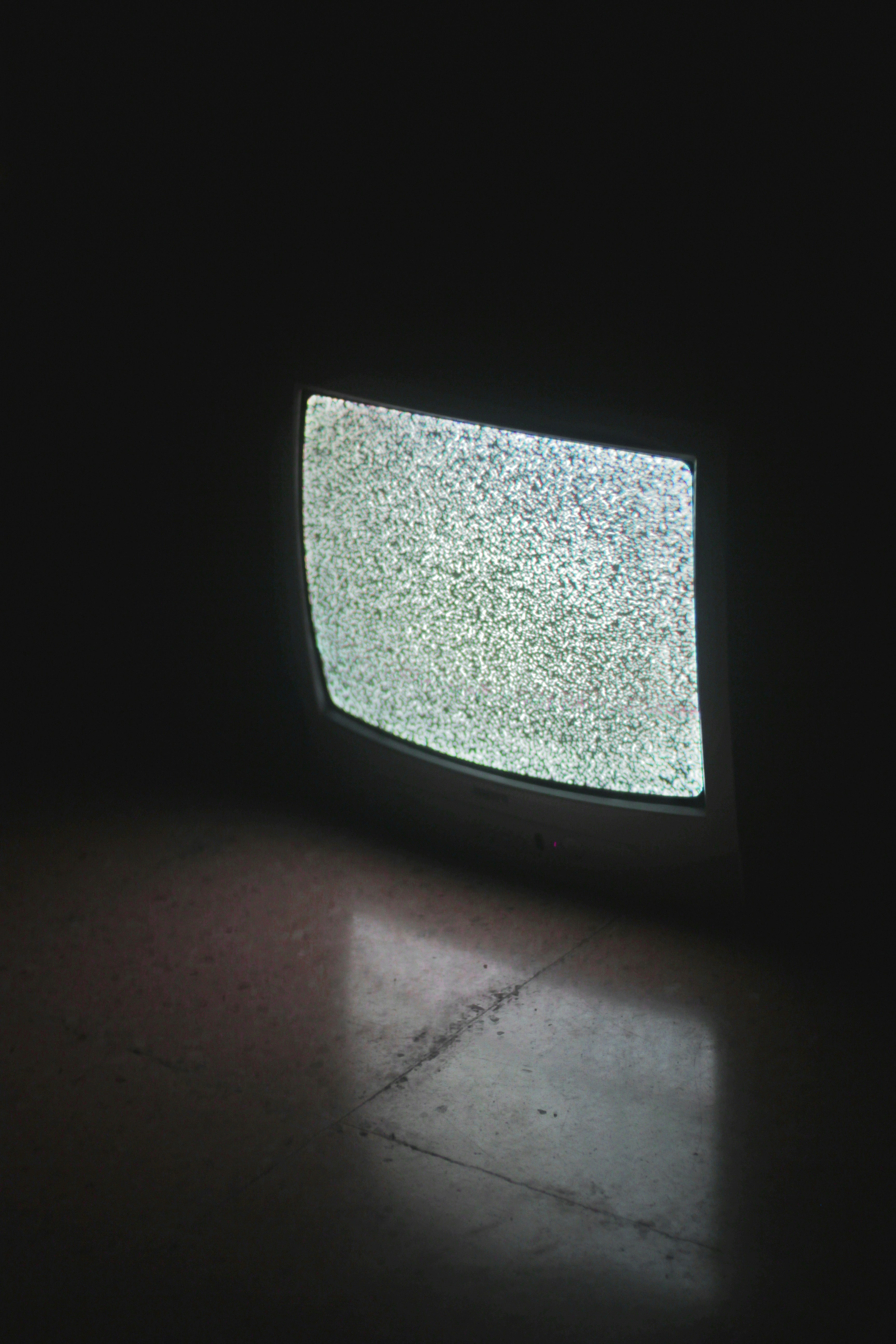 Old tv with no signal by TV Brands gray crt tv turned on in a dark room