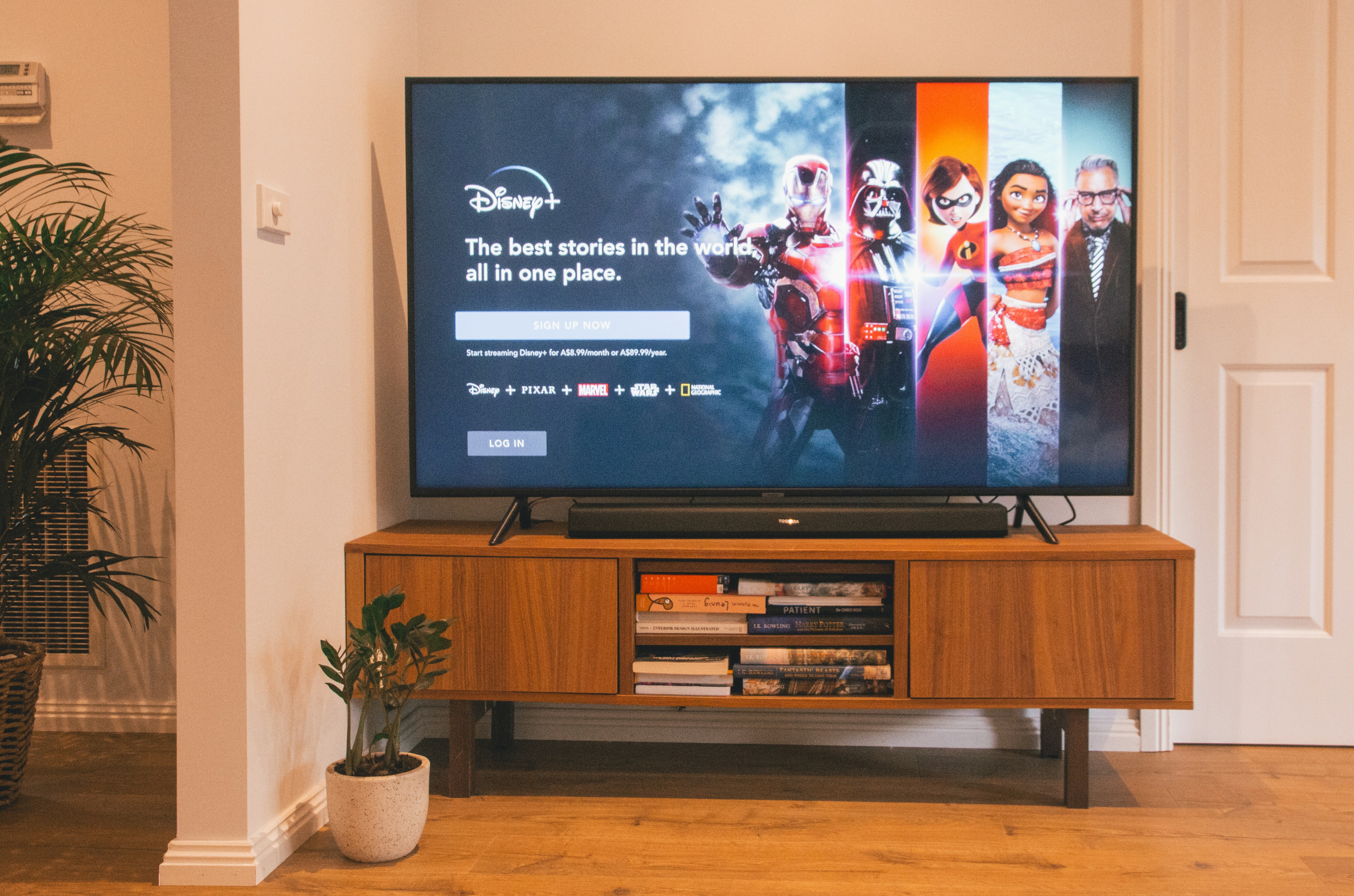 Brands with AI Upscaling by TV Brands black flat screen tv turned on on brown wooden tv rack
