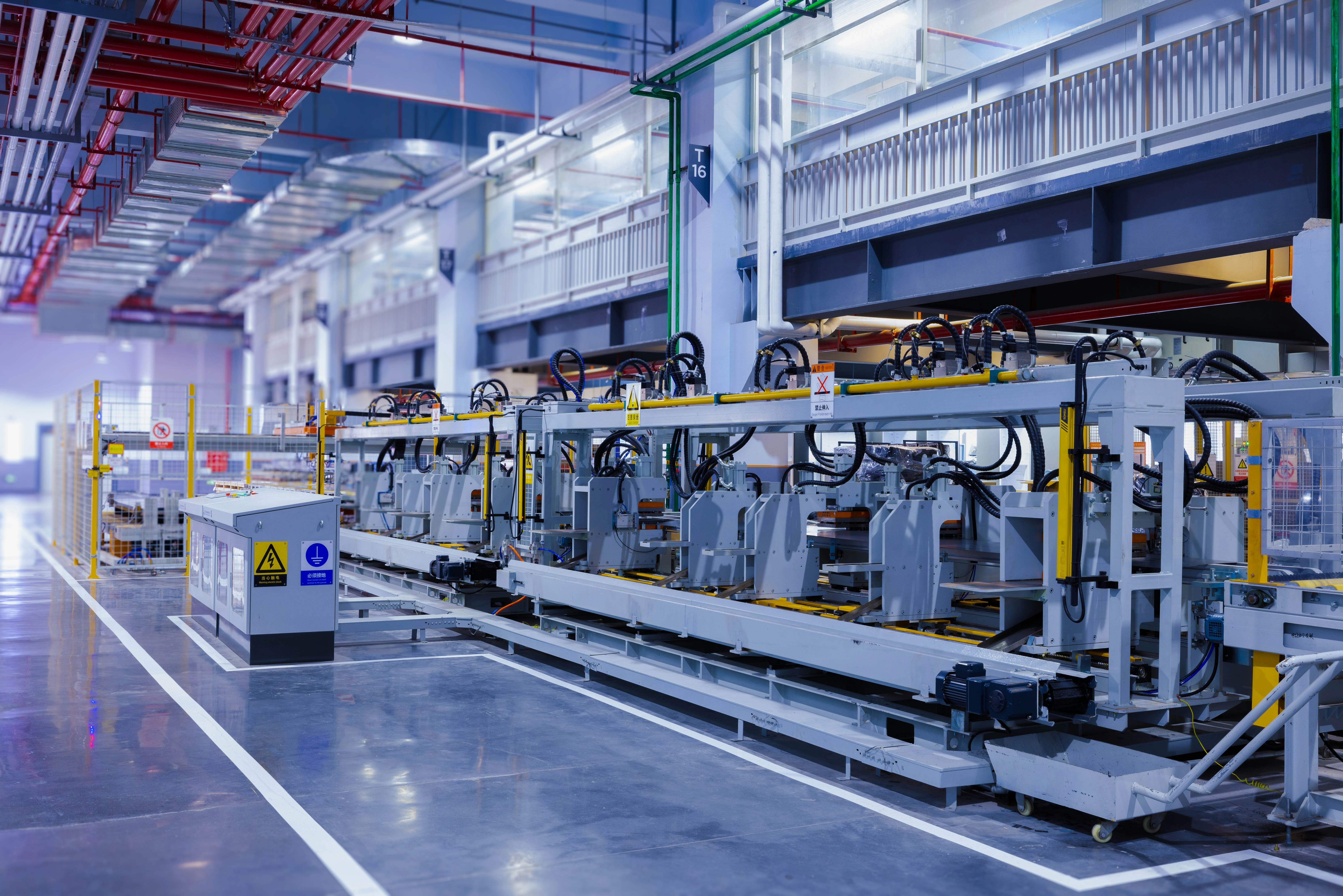 A view of the refrigerator manufacturing plant's fully automated side panel forming line.Translation: a large machine in a large building